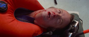 Movie still from “Jaws 2” (1978), directed by Jeannot Szwarc – A man with a knife in his mouth and blood on his face; Close Up shot, Overhead angle