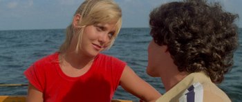 Movie still from “Jaws 2” (1978), directed by Jeannot Szwarc – A young woman and a young man sitting in front of a body of water; Close Up shot, Over the shoulder angle