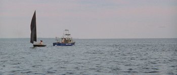 Movie still from “Jaws 2” (1978), directed by Jeannot Szwarc – A small boat floating on top of a large body of water; Extreme Wide shot, High angle