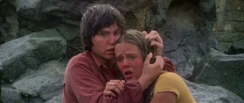 Movie still from “Jaws 2” (1978), directed by Jeannot Szwarc – A man and a woman holding each other in front of a rock wall; Close Up shot, Low angle