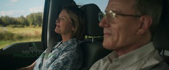 Movie still from “Jerry and Marge Go Large” (2022), directed by David Frankel – An older man and woman sitting in the back seat of a car; Medium shot, Over the shoulder angle