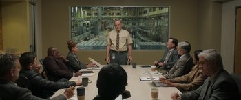 Movie still from “Jerry and Marge Go Large” (2022), directed by David Frankel – A group of people sitting around a table with papers; Medium shot, Over the shoulder angle