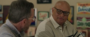 Movie still from “Jerry and Marge Go Large” (2022), directed by David Frankel – A man with glasses is sitting next to another man; Close Up shot, Over the shoulder angle