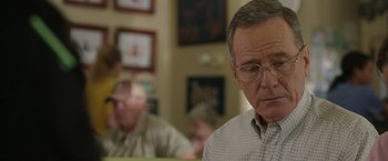 Movie still from “Jerry and Marge Go Large” (2022), directed by David Frankel – An older man wearing glasses looking down at a table; Close Up shot, Over the shoulder angle