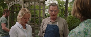 Movie still from “Jerry and Marge Go Large” (2022), directed by David Frankel – An older man wearing an apron standing next to a young girl; Close Up shot, Over the shoulder angle
