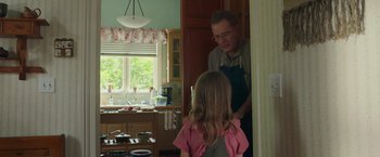 Movie still from “Jerry and Marge Go Large” (2022), directed by David Frankel – An older man and a young girl in a kitchen; Medium shot, Over the shoulder angle