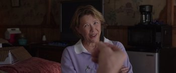 Movie still from “Jerry and Marge Go Large” (2022), directed by David Frankel – An older woman sitting in front of a television; Close Up shot, Over the shoulder angle