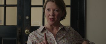 Movie still from “Jerry and Marge Go Large” (2022), directed by David Frankel – An older woman with short blonde hair wearing a floral shirt; Close Up shot, Over the shoulder angle