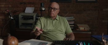 Movie still from “Jerry and Marge Go Large” (2022), directed by David Frankel – A man sitting in front of a computer keyboard; Medium shot, Over the shoulder angle