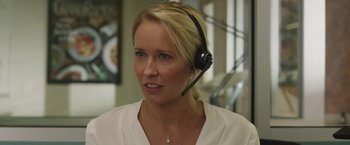 Movie still from “Jerry and Marge Go Large” (2022), directed by David Frankel – A woman wearing a headset in an office setting; Close Up shot, Over the shoulder angle