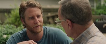 Movie still from “Jerry and Marge Go Large” (2022), directed by David Frankel – A man talking to another man while sitting on a bench; Close Up shot, Over the shoulder angle