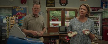 Movie still from “Jerry and Marge Go Large” (2022), directed by David Frankel – A man and a woman standing next to each other in a store; Medium shot, Over the shoulder angle