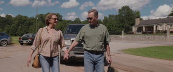 Movie still from “Jerry and Marge Go Large” (2022), directed by David Frankel – An older man and woman holding hands while walking down the street; Medium shot, Low angle