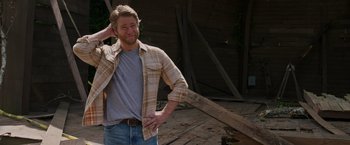 Movie still from “Jerry and Marge Go Large” (2022), directed by David Frankel – A man in a plaid shirt is standing outside; Medium shot, Over the shoulder angle