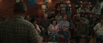 Movie still from “Jerry and Marge Go Large” (2022), directed by David Frankel – A group of people sitting in a living room; Wide shot, High angle