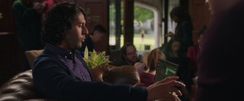 Movie still from “Jerry and Marge Go Large” (2022), directed by David Frankel – A man sitting in front of a laptop computer; Medium shot, Over the shoulder angle