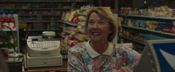 Movie still from “Jerry and Marge Go Large” (2022), directed by David Frankel – A woman in a floral shirt smiles at the camera; Close Up shot, Over the shoulder angle