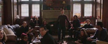 Movie still from “Jerry and Marge Go Large” (2022), directed by David Frankel – A group of people sitting in a living room; Wide shot, Over the shoulder angle