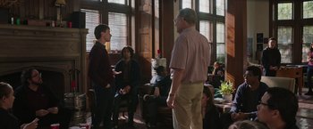 Movie still from “Jerry and Marge Go Large” (2022), directed by David Frankel – A group of people standing around in a living room; Wide shot, Over the shoulder angle