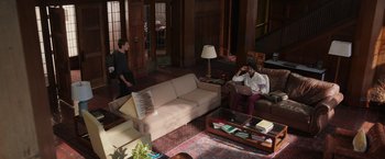 Movie still from “Jerry and Marge Go Large” (2022), directed by David Frankel – Two people in a living room talking on the phone; Extreme Wide shot, High angle