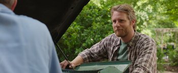 Movie still from “Jerry and Marge Go Large” (2022), directed by David Frankel – A man looking at something under the hood of a car; Close Up shot, Over the shoulder angle