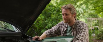 Movie still from “Jerry and Marge Go Large” (2022), directed by David Frankel – A man looking under the hood of an open car; Close Up shot, Low angle