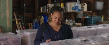 Movie still from “Jerry and Marge Go Large” (2022), directed by David Frankel – A woman is looking at a piece of paper in a box; Medium shot, Over the shoulder angle