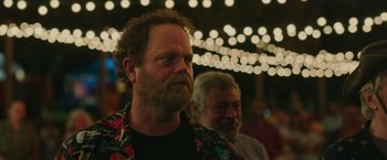 Movie still from “Jerry and Marge Go Large” (2022), directed by David Frankel – A man with a beard is looking at the camera; Close Up shot, Over the shoulder angle