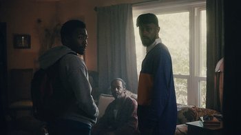 Movie still from “Atlanta” (2016), created by Donald Glover – A group of men standing in front of a window; Medium shot, Over the shoulder angle