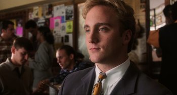 Movie still from “Jerry Maguire” (1996), directed by Cameron Crowe – A man in a suit and tie looking at the camera; Close Up shot, Over the shoulder angle