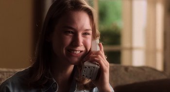 Movie still from “Jerry Maguire” (1996), directed by Cameron Crowe – A woman smiles as she talks on a cell phone; Close Up shot, Low angle