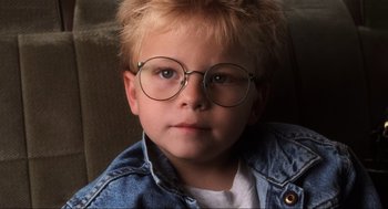 Movie still from “Jerry Maguire” (1996), directed by Cameron Crowe – A young boy wearing glasses and a jean jacket; Close Up shot, High angle