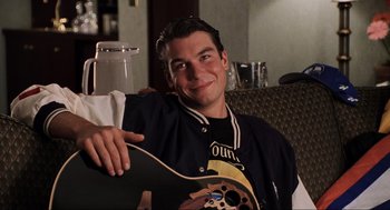 Movie still from “Jerry Maguire” (1996), directed by Cameron Crowe – A man holding a skateboard in his hand; Close Up shot, Over the shoulder angle