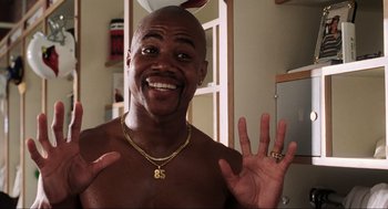 Movie still from “Jerry Maguire” (1996), directed by Cameron Crowe – A bald man with a gold chain around his neck; Close Up shot, High angle
