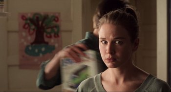 Movie still from “Jerry Maguire” (1996), directed by Cameron Crowe – A young woman looking at the camera while a young man is brushing her hair; Close Up shot, Over the shoulder angle
