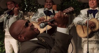 Movie still from “Jerry Maguire” (1996), directed by Cameron Crowe – A man singing into a microphone in front of a man playing a guitar; Medium shot, Low angle
