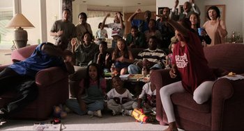 Movie still from “Jerry Maguire” (1996), directed by Cameron Crowe – A group of people sitting on the floor in a room; Wide shot, High angle