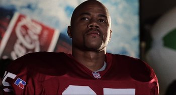 Movie still from “Jerry Maguire” (1996), directed by Cameron Crowe – A man in a football uniform is looking up; Close Up shot, Low angle
