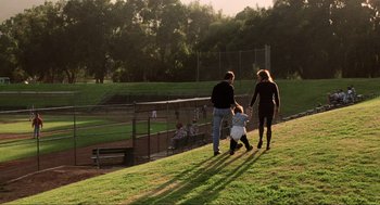 Movie still from “Jerry Maguire” (1996), directed by Cameron Crowe – A group of people walking across a grass covered field; Wide shot, High angle