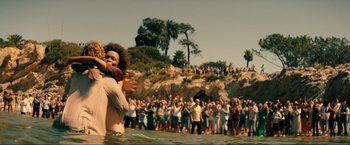 Movie still from “Jesus Revolution” (2023), directed by Brent McCorkle – A crowd of people standing in the water at the beach; Wide shot, High angle