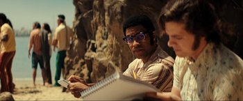 Movie still from “Jesus Revolution” (2023), directed by Brent McCorkle – A man with glasses is looking at a notebook; Medium shot, Low angle