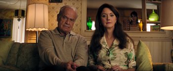 Movie still from “Jesus Revolution” (2023), directed by Brent McCorkle – An older man and a younger woman sitting next to each other; Close Up shot, High angle