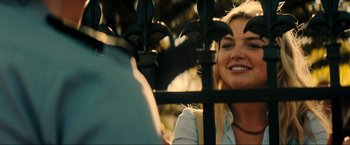 Movie still from “Jesus Revolution” (2023), directed by Brent McCorkle – A beautiful young lady looking over a fence; Close Up shot, Over the shoulder angle