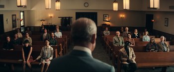 Movie still from “Jesus Revolution” (2023), directed by Brent McCorkle – A group of people sitting in pews in a church; Wide shot, Over the shoulder angle