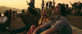 Movie still from “Jesus Revolution” (2023), directed by Brent McCorkle – A man and a woman sitting next to each other; Medium shot, Low angle