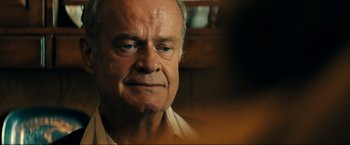 Movie still from “Jesus Revolution” (2023), directed by Brent McCorkle – An older man with a blue eye stares into the distance; Close Up shot, Over the shoulder angle