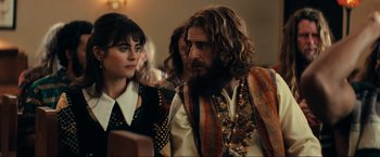 Movie still from “Jesus Revolution” (2023), directed by Brent McCorkle – A man and a woman are standing next to each other; Medium shot, Over the shoulder angle