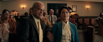 Movie still from “Jesus Revolution” (2023), directed by Brent McCorkle – A man and a woman are standing next to each other in front of other people; Medium shot, Low angle