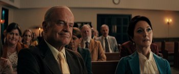 Movie still from “Jesus Revolution” (2023), directed by Brent McCorkle – A group of people sitting in front of a crowd; Close Up shot, Low angle