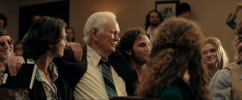 Movie still from “Jesus Revolution” (2023), directed by Brent McCorkle – An older man and a younger man are posing for a picture; Medium shot, Over the shoulder angle